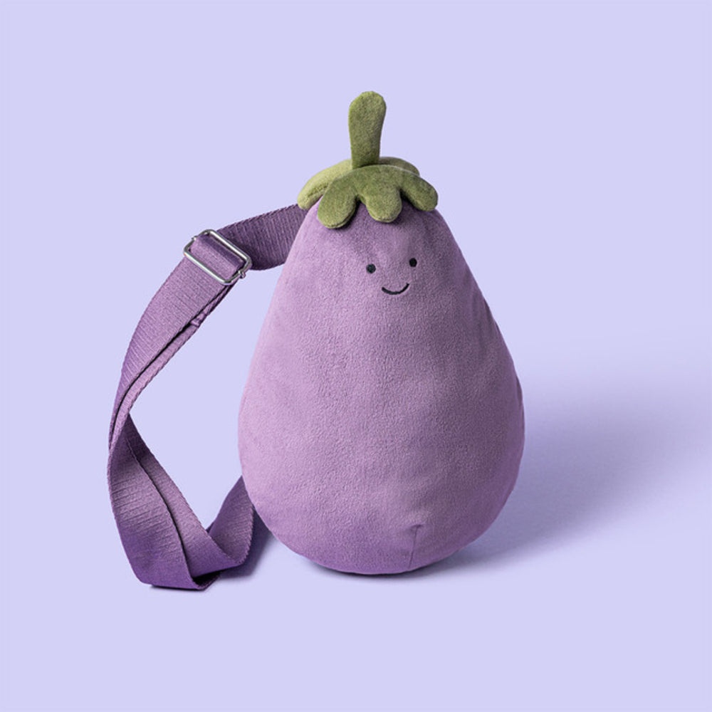 Plush toy shaped like an eggplant with a smiling face on a light purple background