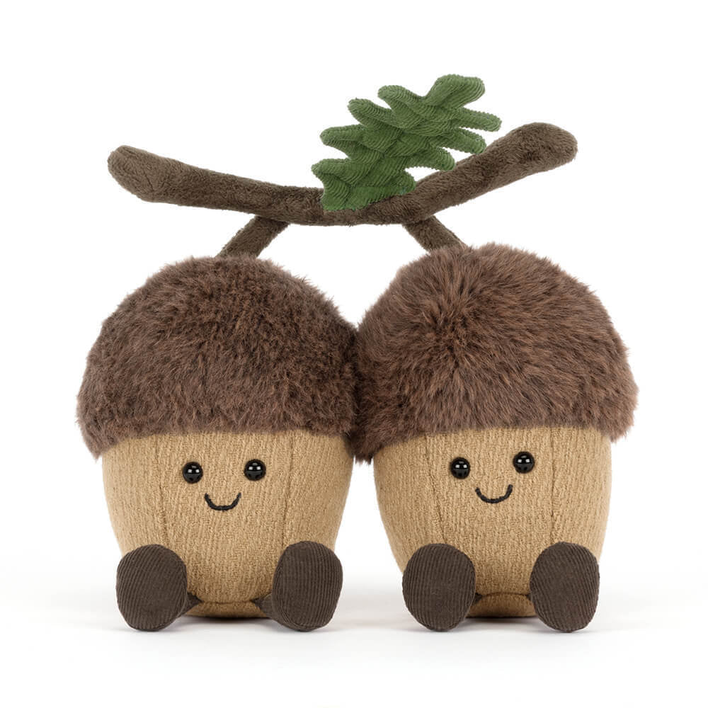 A front facing photo of a stuffed toy acorn with a branch on a white background.