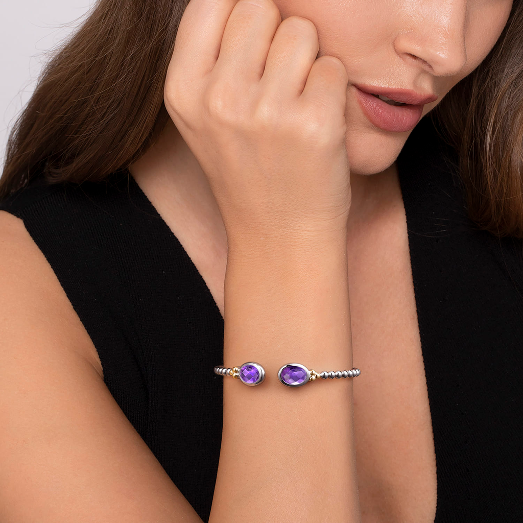 Girl wearing Silver beaded bracelet with purple gemstones on a white background