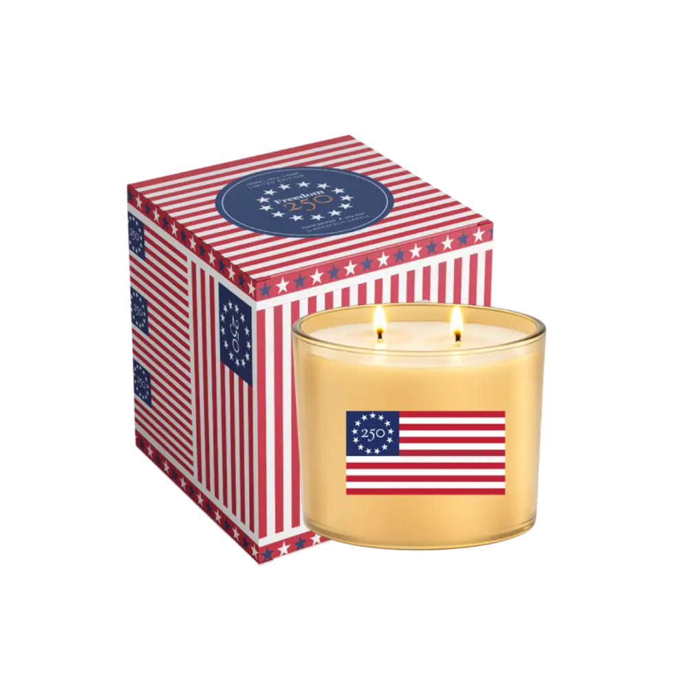 Candle with American flag design in front of a matching box on a white background.