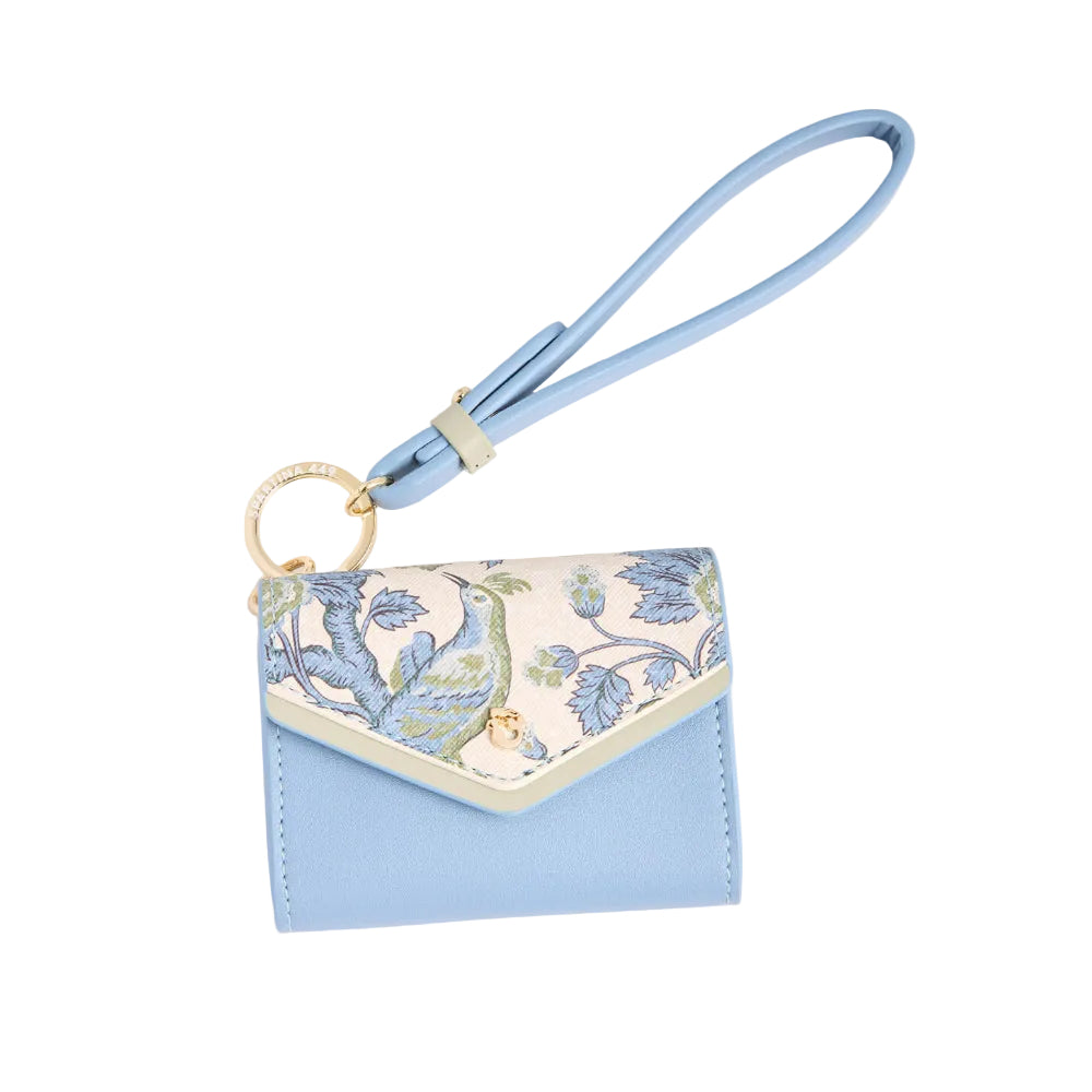 A light blue leather wristlet pouch with a floral-patterned flap and a matching blue wrist strap, shown on a warm cream background.