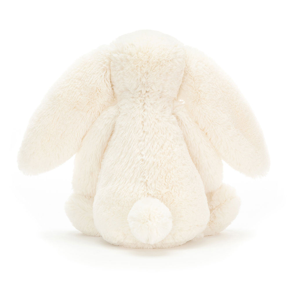 A photo of the back of a medium/original sized cream-colored plush bunny toy on a white background.