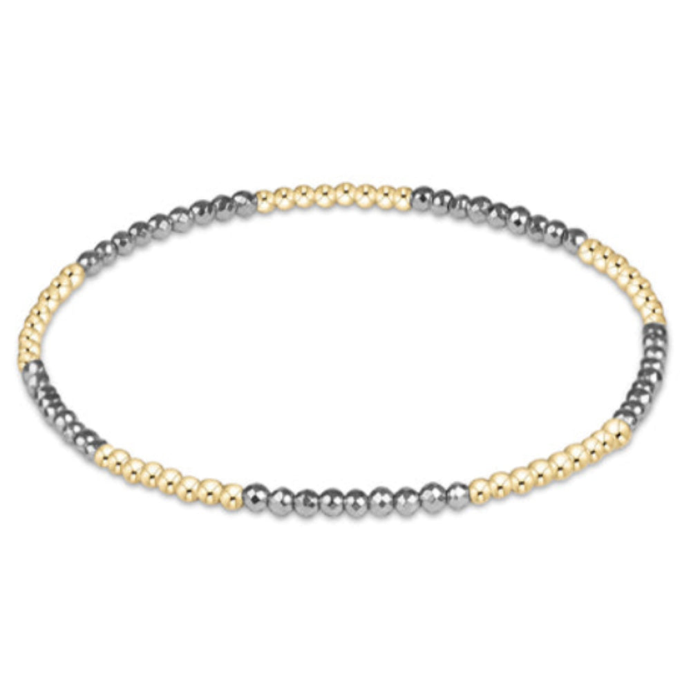 A delicate beaded stretch bracelet featuring alternating strands of small gold and silver-toned beads, displayed on a clean white background.