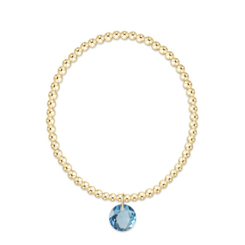 Gold bracelet with a blue gemstone on a white background