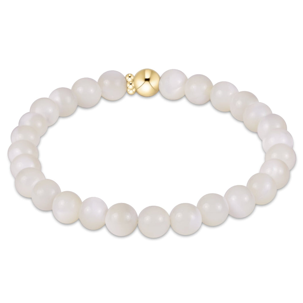 A beaded stretch bracelet made of smooth, round off-white beads with a polished gold clasp, shown on a clean white background.