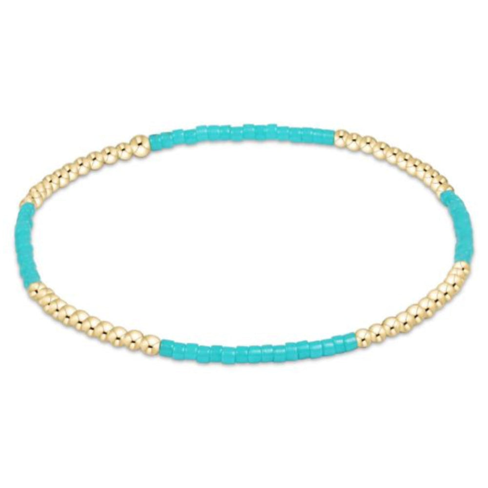 Beaded bracelet with turquoise beads and gold accents on a white background