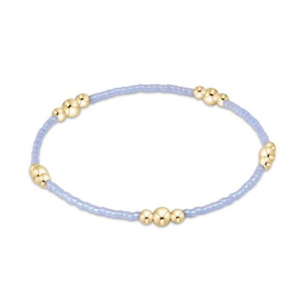 Bracelet with gold and light blue beads against a white background