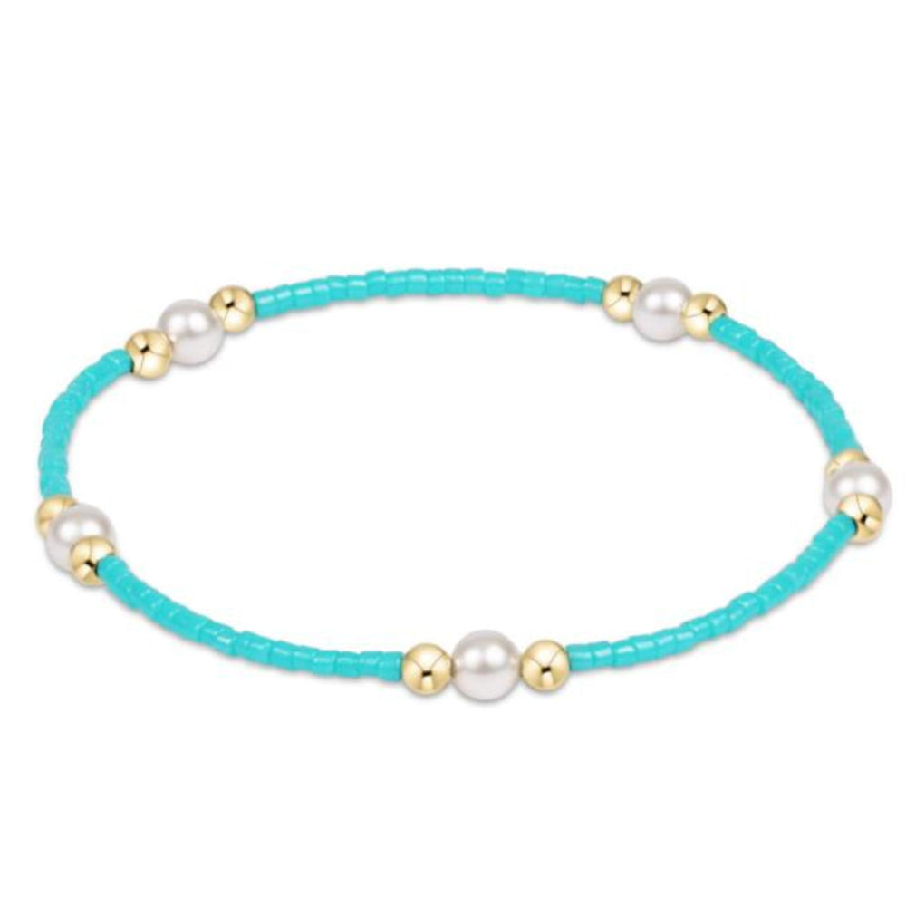 Turquoise bracelet with pearls and gold beads on a white background