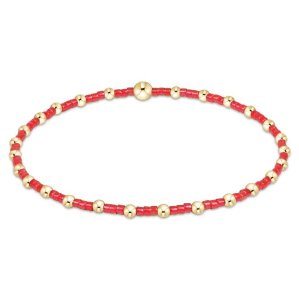 Bracelet with red and gold beads on a white background