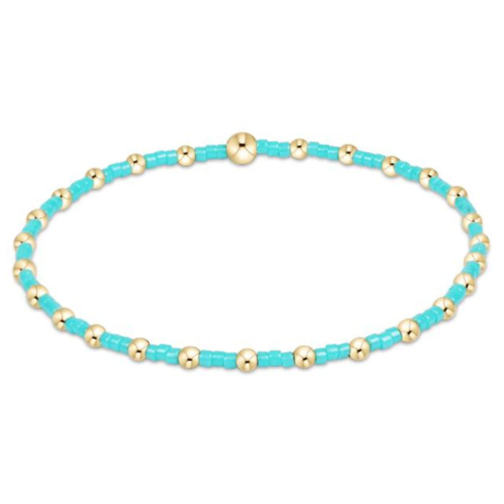 Turquoise and gold beaded bracelet on a white background