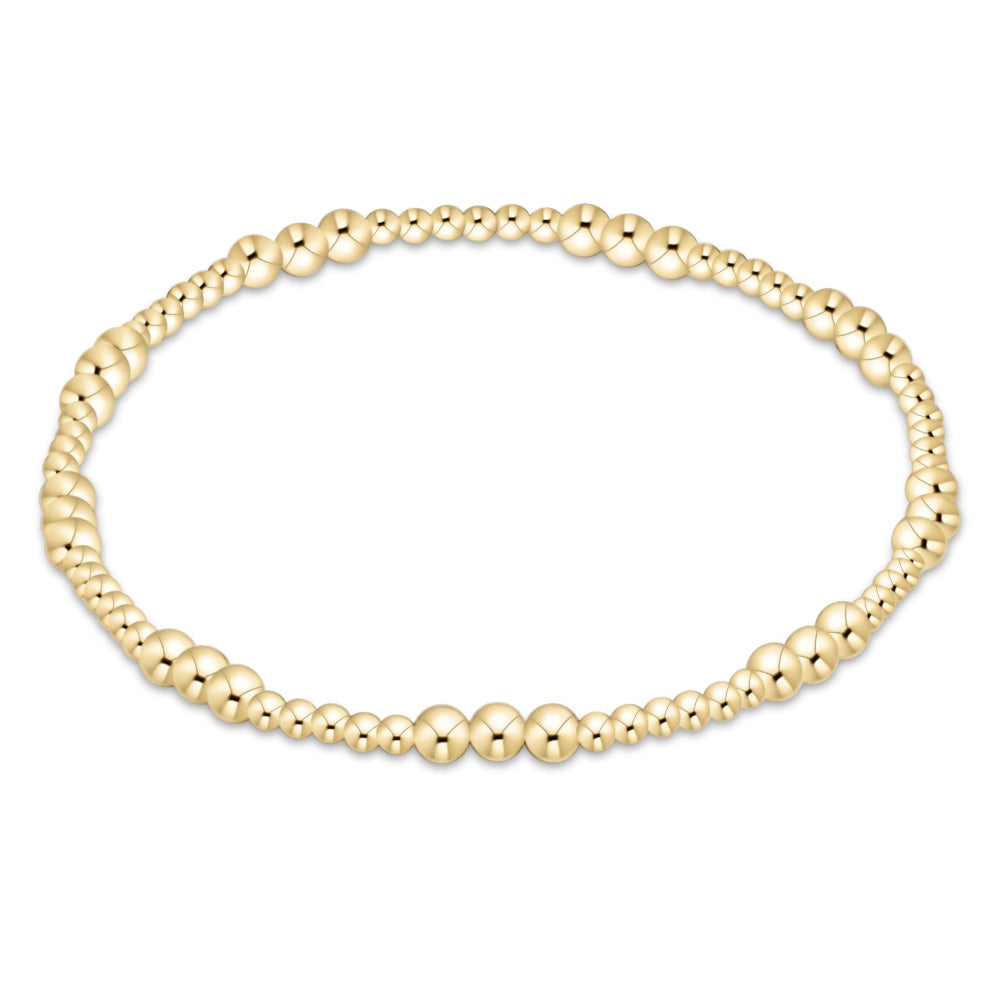A delicate gold beaded bracelet with a textured, woven look, displayed on a clean white background.