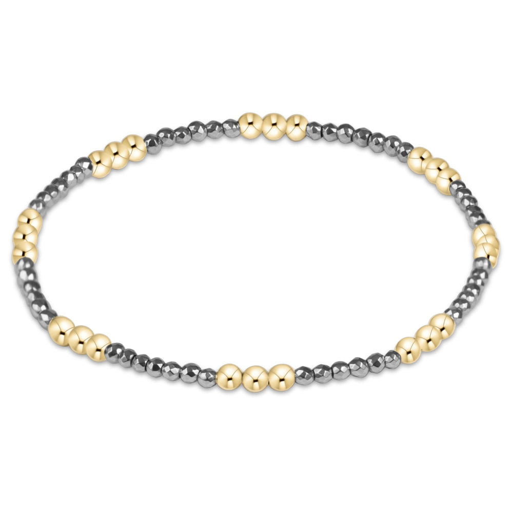 A delicate beaded stretch bracelet featuring alternating strands of small metallic silver beads and matte gold round beads, displayed on a clean white background.
