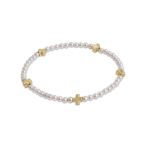 Pearl bracelet with gold crosses on a white background