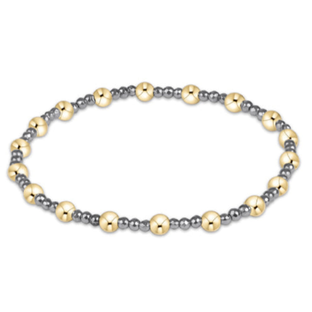 A beaded stretch bracelet featuring alternating polished gold-tone and matte silver-tone beads, arranged in a circular shape against a plain white background.