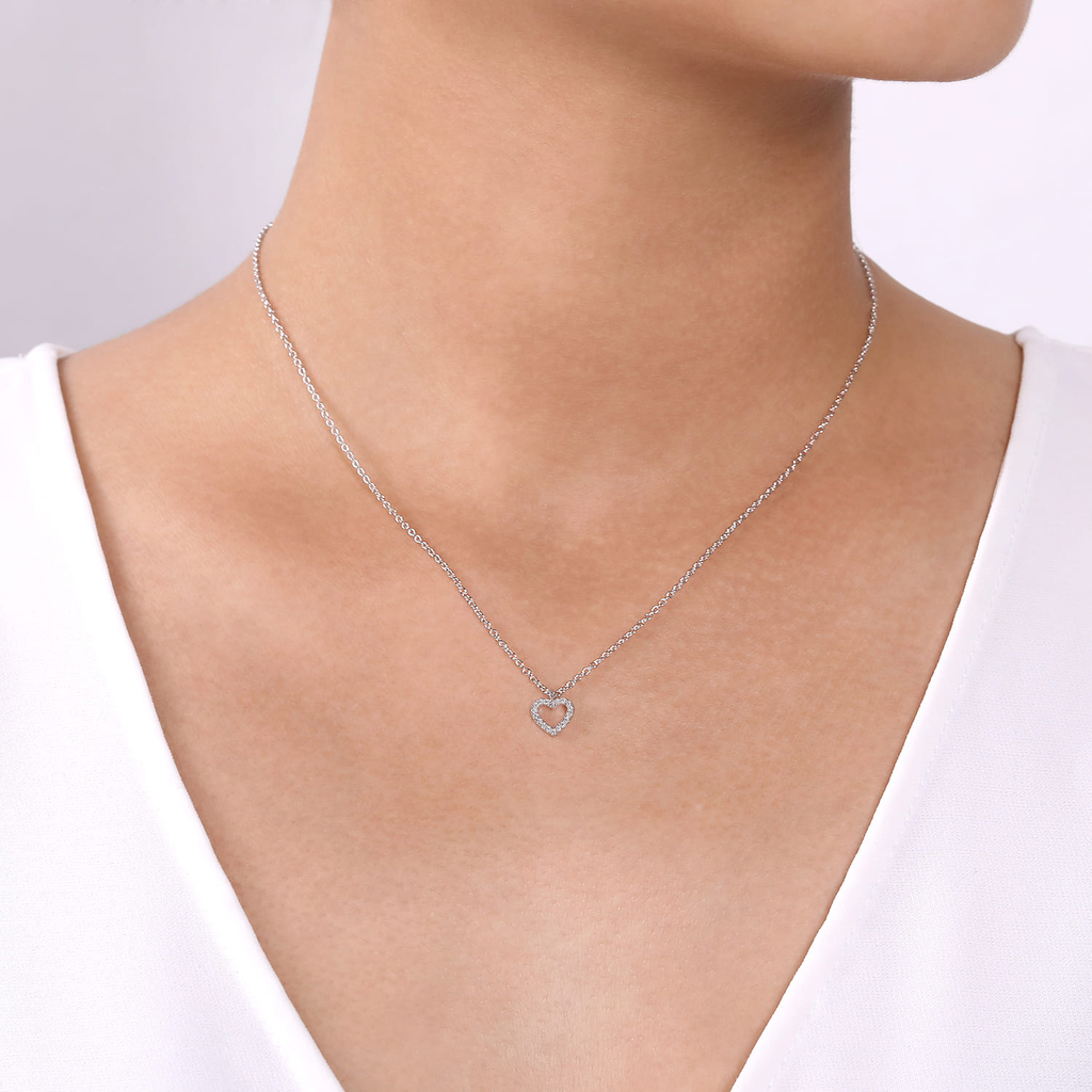 Silver necklace with a heart pendant on a white background