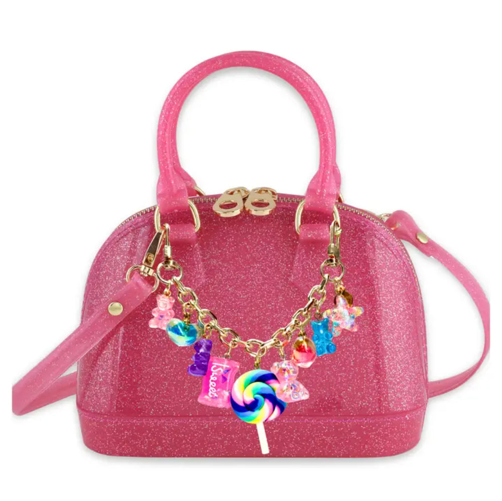 Pink handbag with colorful charm on a white background