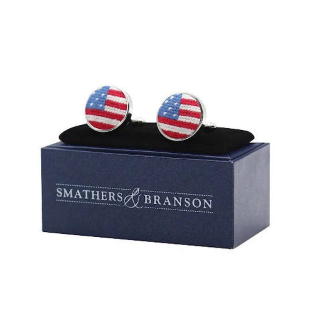 Pair of needlepoint american flag cufflinks on a navy blue Smathers & Branson box.