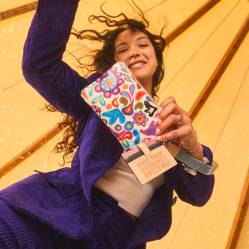 Woman holding a colorful wallet with a wooden floor background