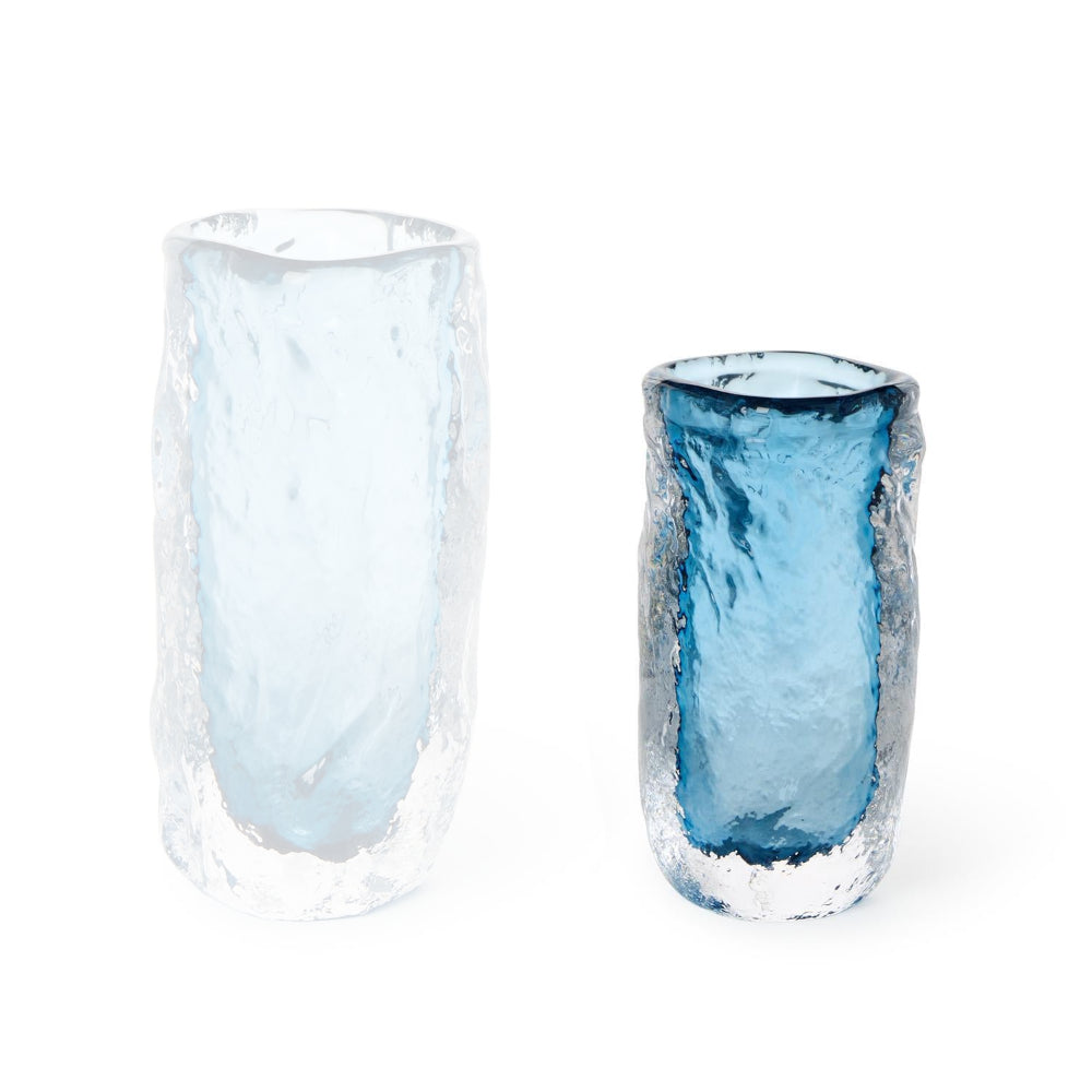 Small blue glass vase with a translucent blue a core on a white backround.