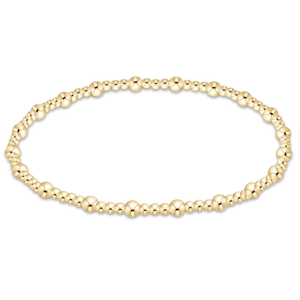 A delicate gold beaded stretch bracelet shown against a plain white background.