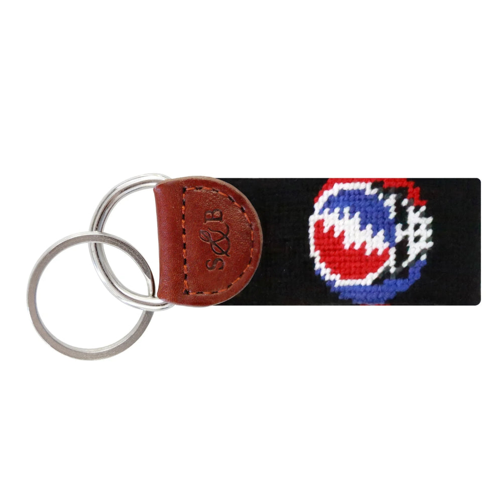 Keychain with a black strap featuring a colorful logo and a brown leather tag on a white background