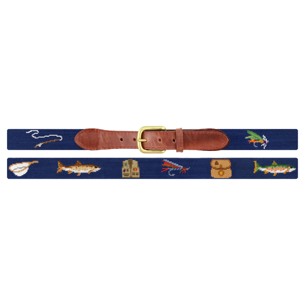 A navy blue woven belt with a brown leather buckle strap and gold-tone metal hardware, decorated with embroidered fishing-themed motifs including fish, lures, a fly, and a small house on both sides.