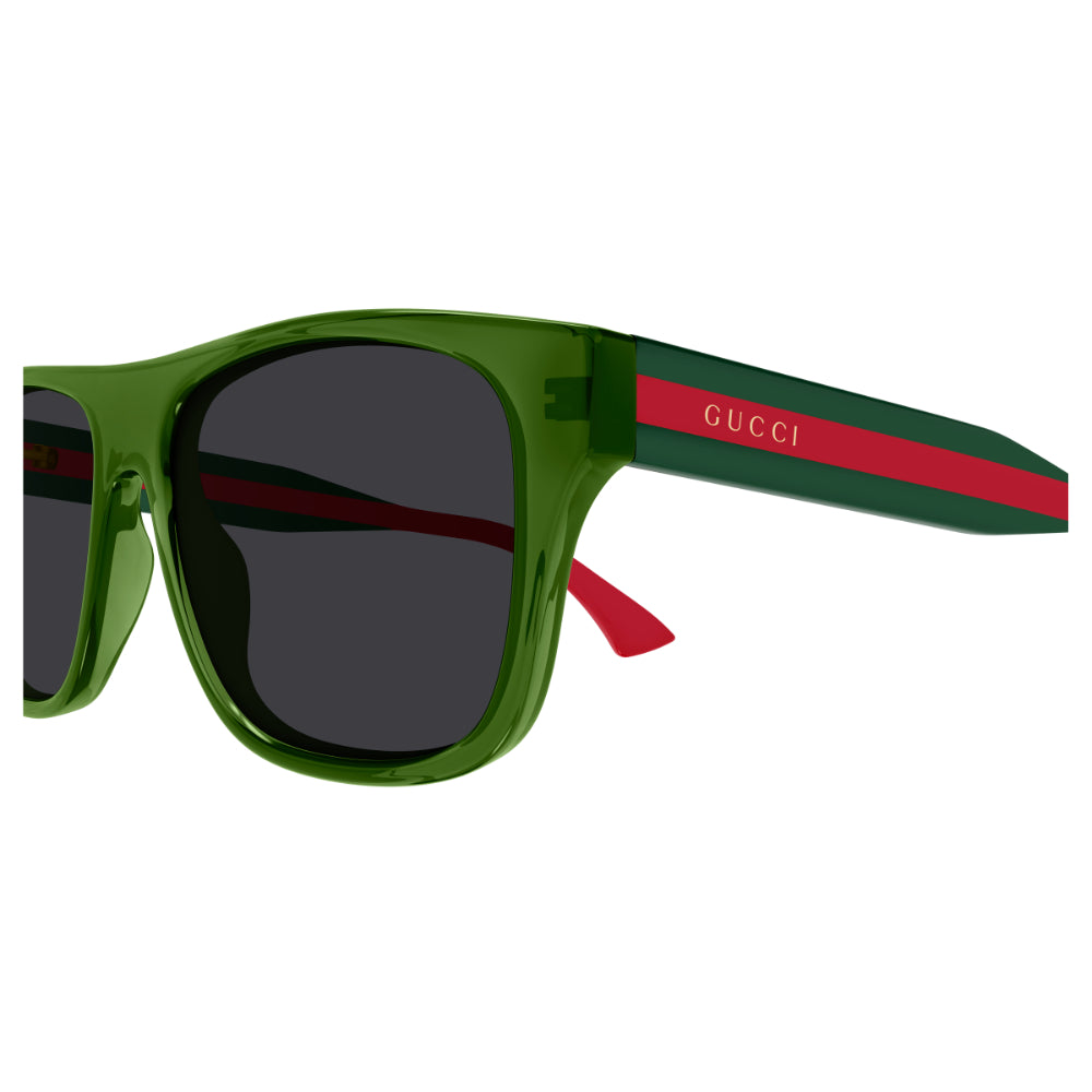 Gucci sunglasses with a translucent olive green frame, dark lenses, and the signature green and red web stripe on the temple arm with the white GUCCI logo.