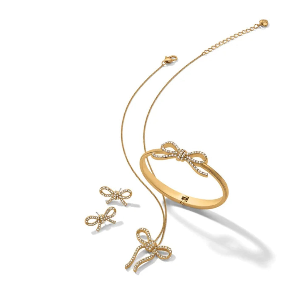 Gold bow-shaped jewelry set on a white background