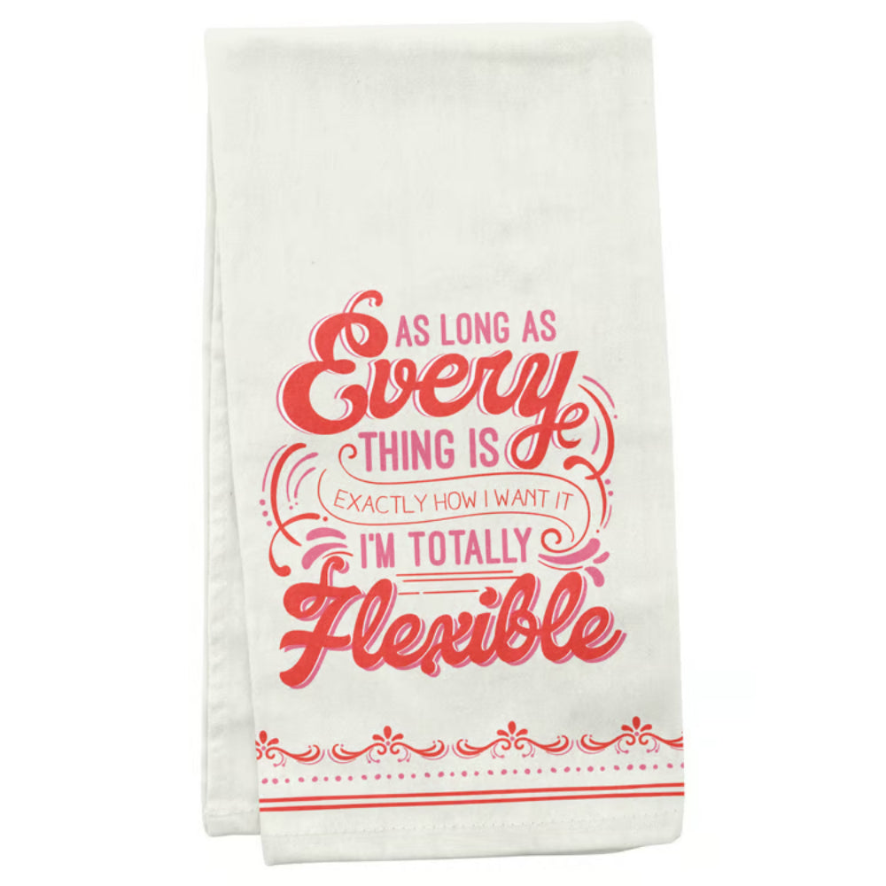An off-white kitchen tea towel featuring a humorous quote in red and pink lettering that reads 'AS LONG AS Every THING IS EXACTLY HOW I WANT IT I'M TOTALLY Flexible' with decorative red patterns along the bottom edge.