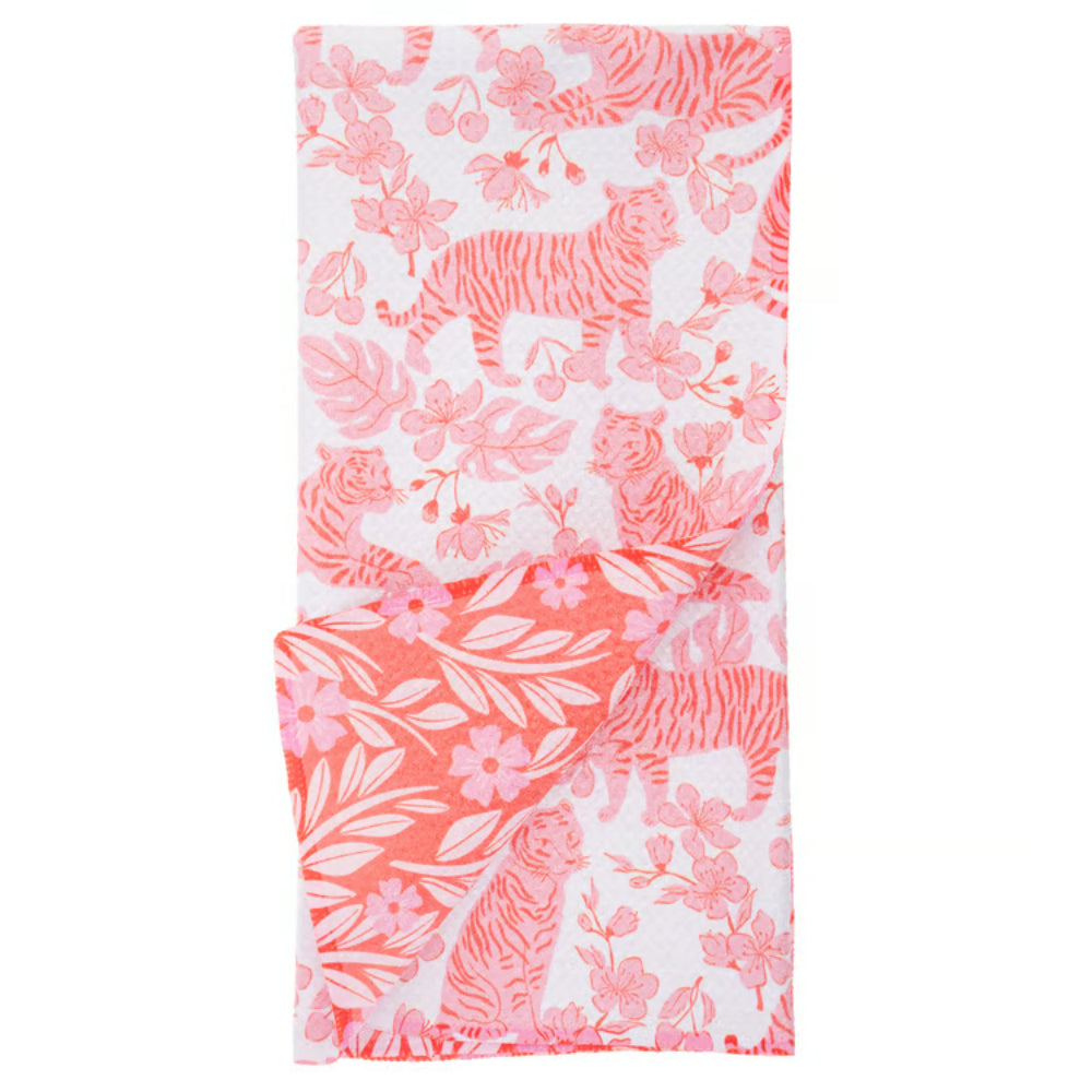 A folded white towel, featuring a vibrant coral pink and pink pattern of tigers, flowers, and leaves.