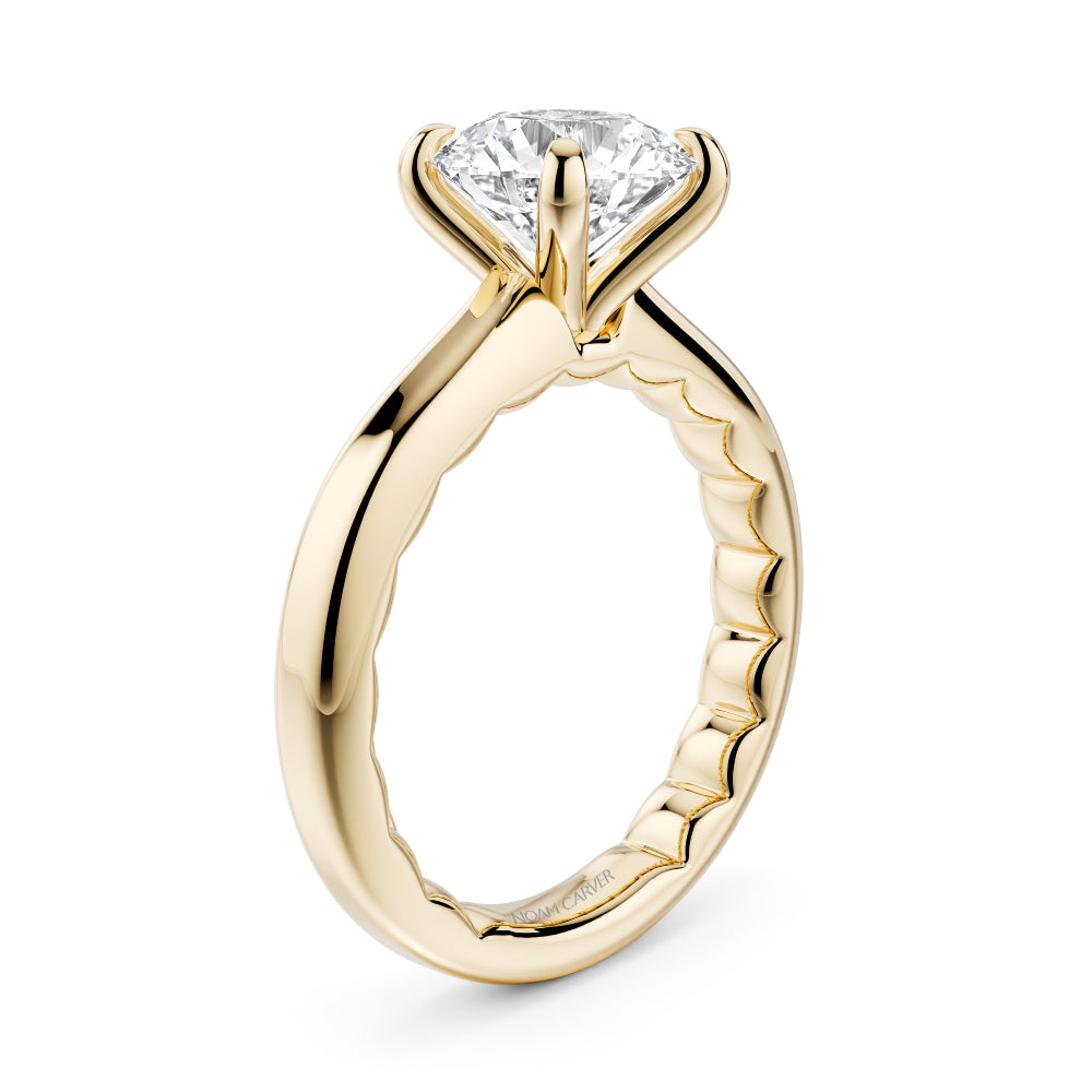 Gold Noam Carver ring with a round diamond on a white background
