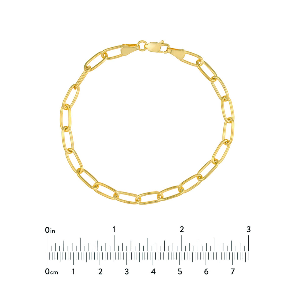 Gold chain bracelet with a ruler for size reference on a white background
