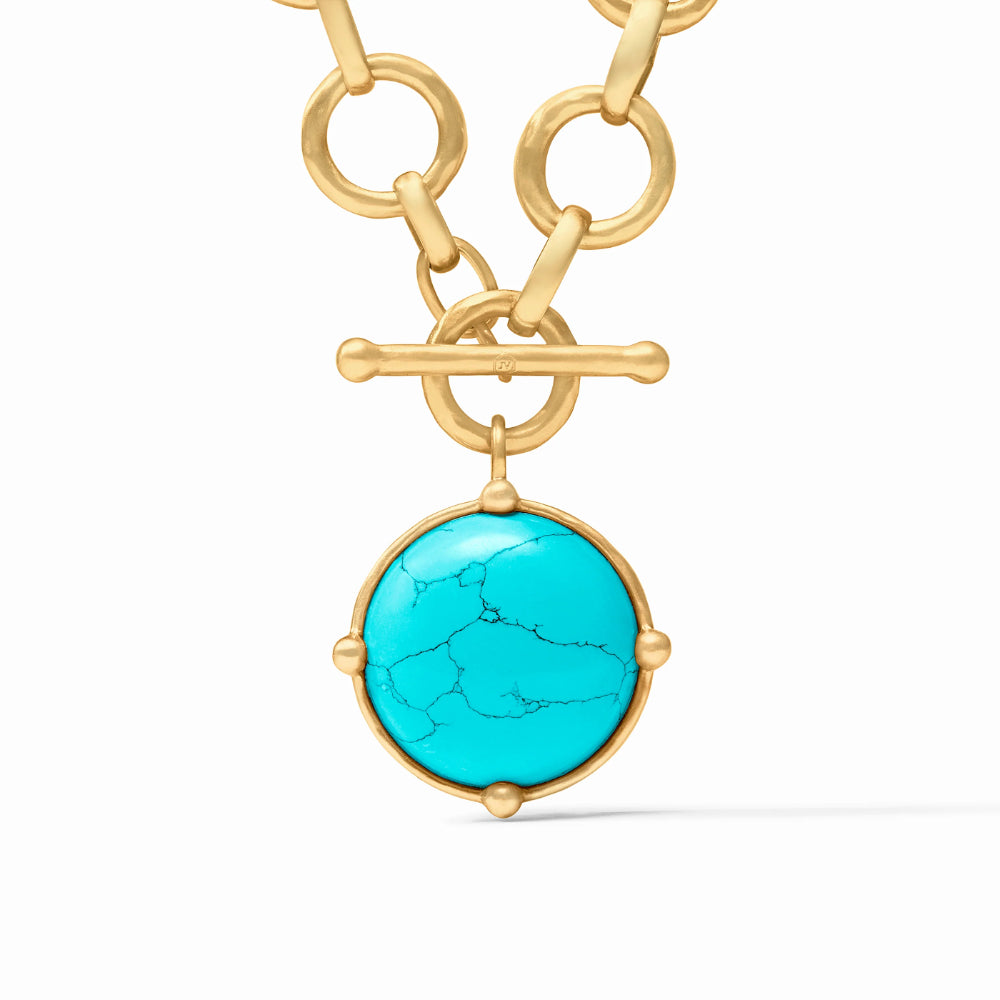 Gold necklace with a turquoise pendant on a white background