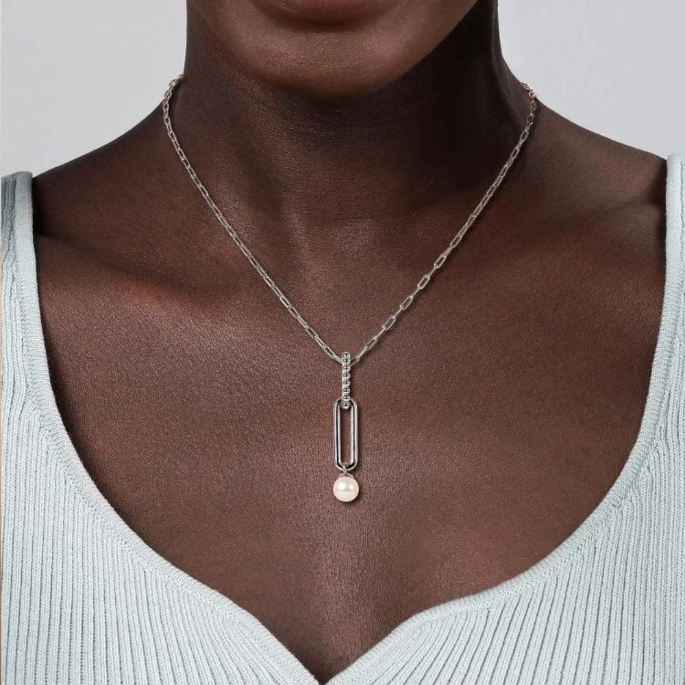 A close-up of woman wearing a silver chain necklace with a Fresh Water Pearl Drop pendant