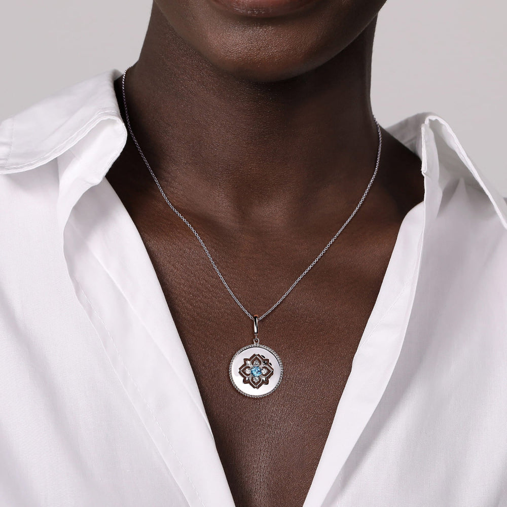 Person wearing Silver Medallion pendant with Blue Topaz and White Sapphires