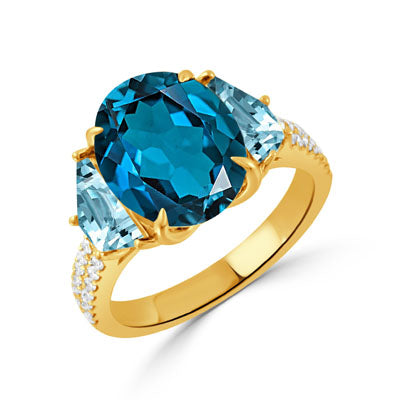 A yellow gold ring featuring a large oval-cut blue topaz center stone and two marquise-cut light blue topaz side stones, accented with small pavé diamonds on the band, set against a plain white background.