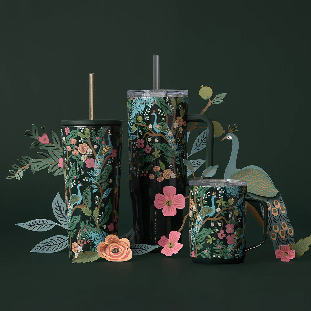 Dark green travel mug with peacock design and other simuar design tumblers on a dark green backround with colorful flowers and a green peacock
