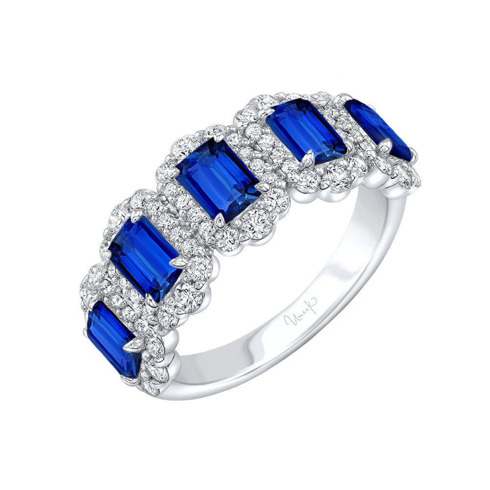 White gold ring with blue sapphires and white diamond halos on a white background