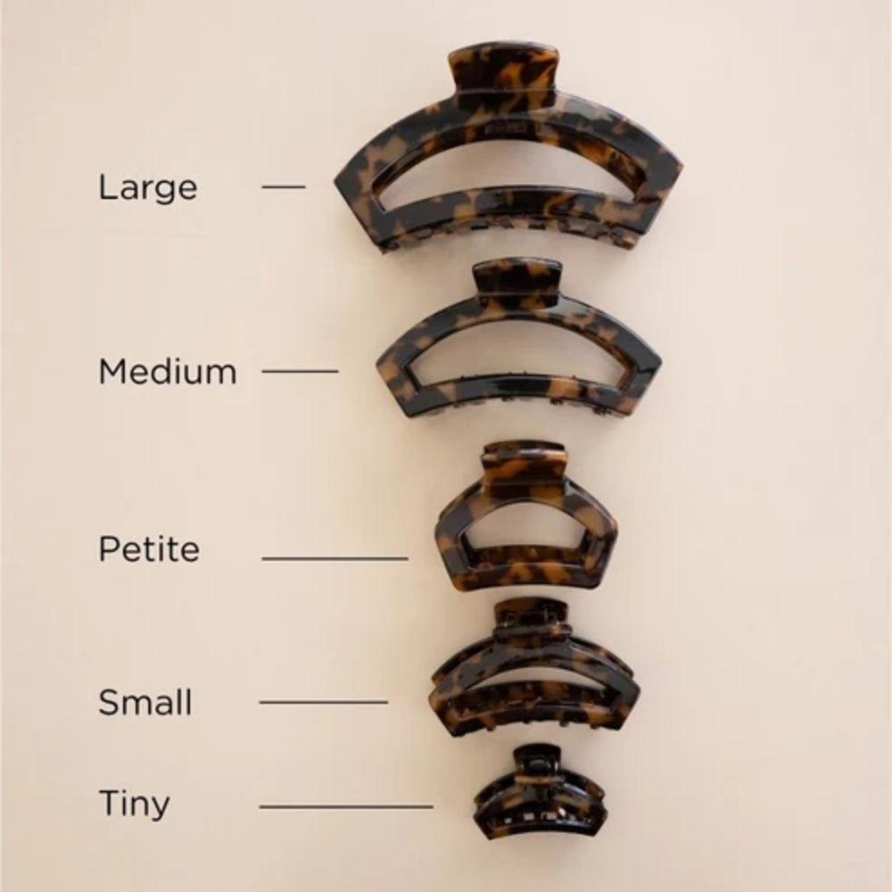 Five tortoiseshell hair claw clips in different sizes labeled Large, Medium, Petite, Small, and Tiny on a light beige background.