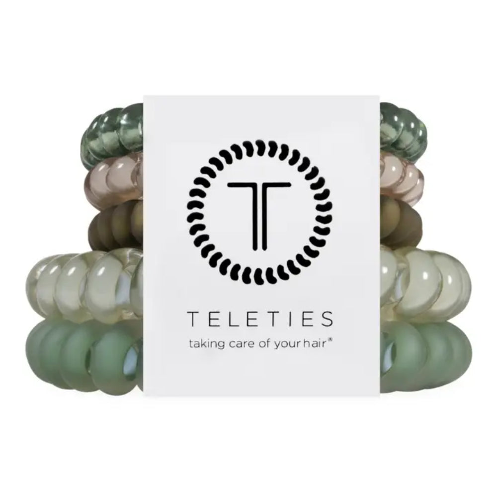A set of five translucent silicone hair extension bands in various shades of sage green, olive, and beige, wrapped in a white paper band featuring the black circular 'T' logo and the brand name 'TELETIES'.