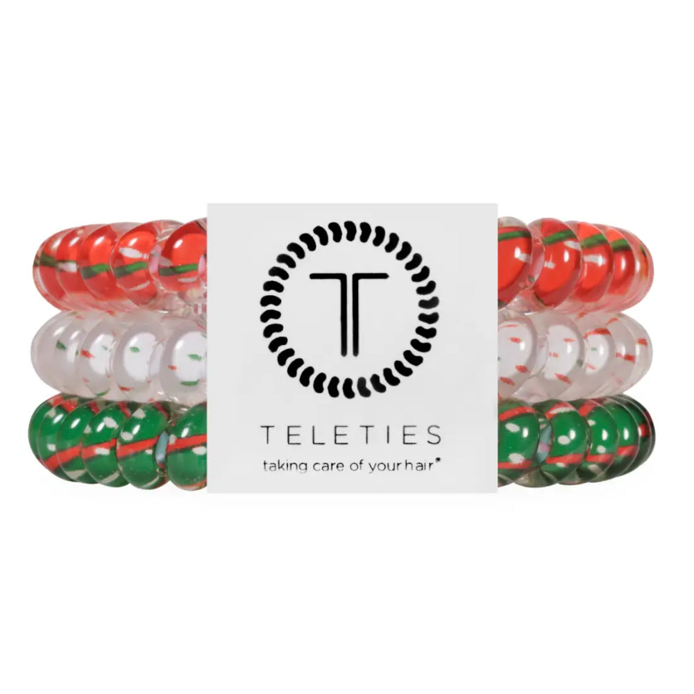 Three elastic hair stretch bands with red, green, and clear beads, arranged behind a white Teleties brand label on a white background.
