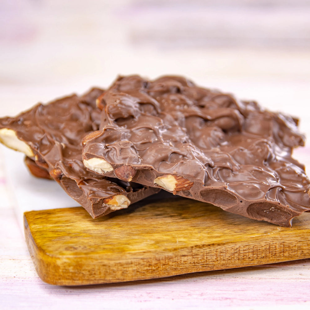 Chocolate bark with nuts on a wooden board.