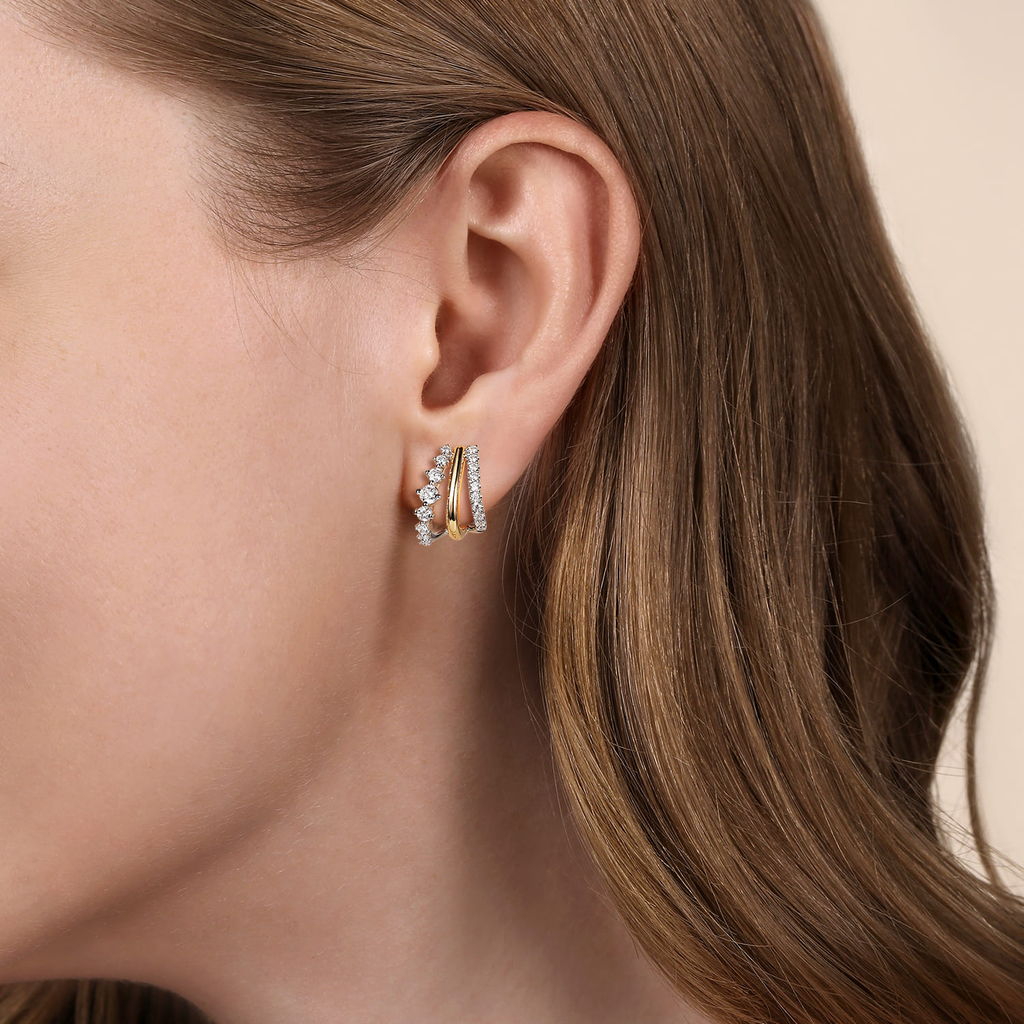 model wearing yellow and silver half hoop earrings with clear stones on natural background