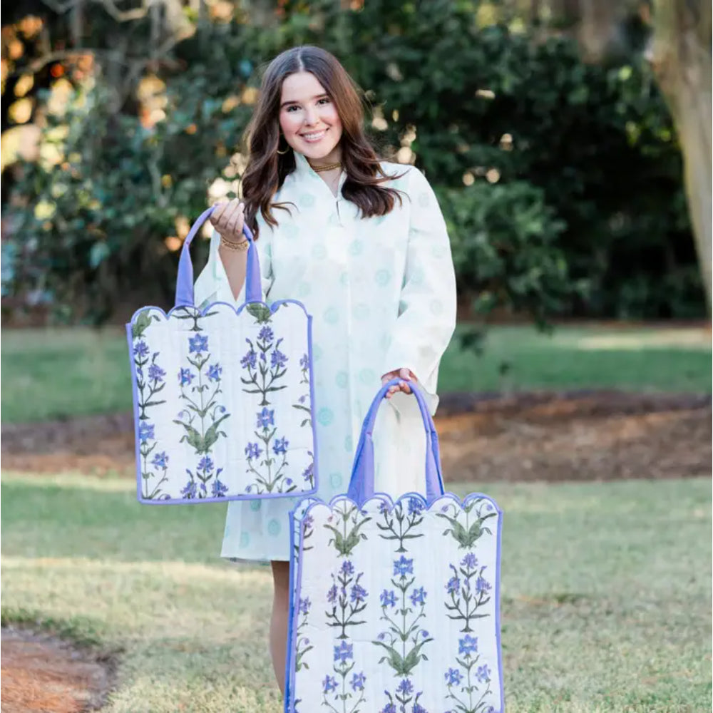 Woman holding two floral-patterned bags outdoors