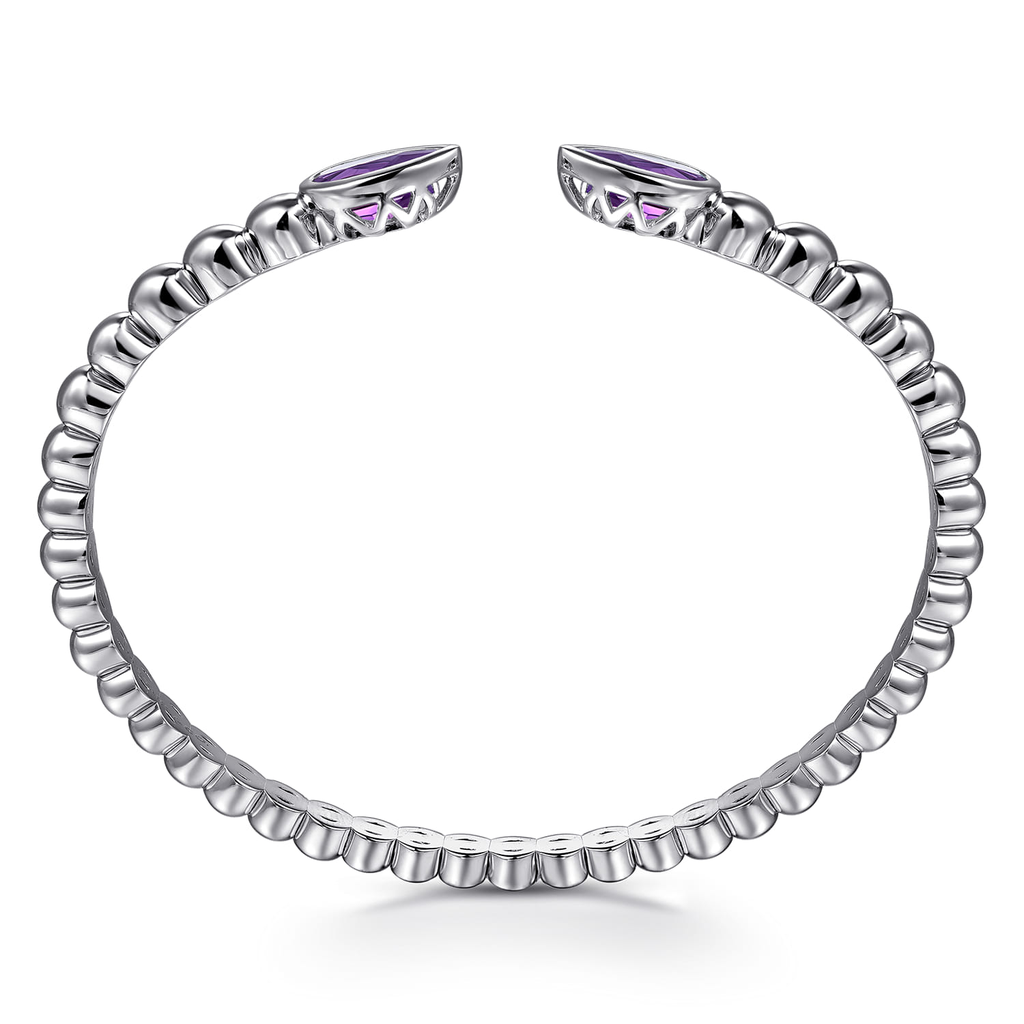 Silver ring with purple gemstones on a white background