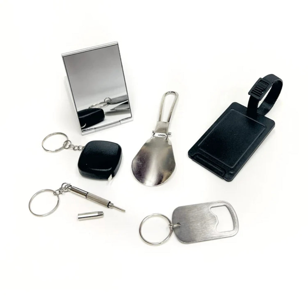 Collection of keychain items including a compact mirror, spoon, and various tags on a white background.