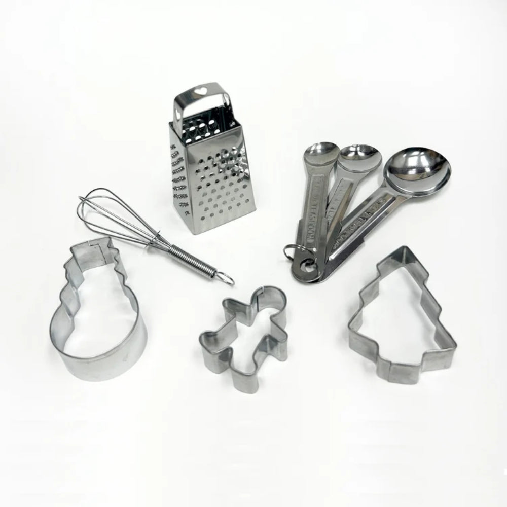 Set of metal kitchen utensils including a whisk, grater, measuring cups and spoons, and cookie cutters on a white background.