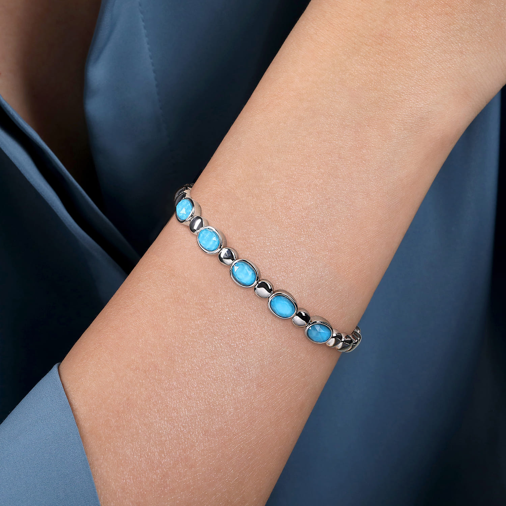 Bracelet with blue stones on a wrist against a dark background