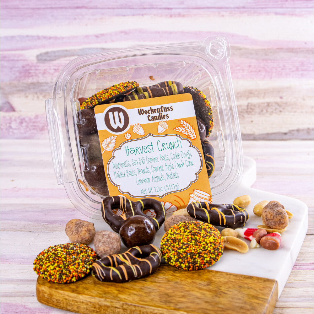 A container from Wockenfuss candies with a variety of candy, chocolate covered pretzels, peanuts, and many more delicious items.