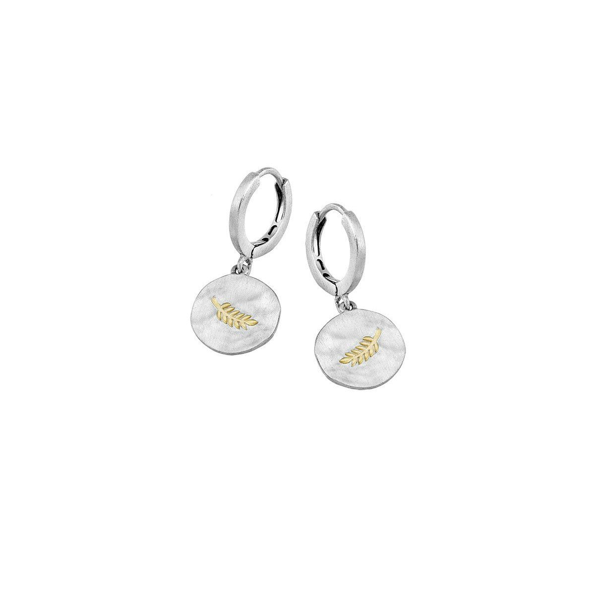 A pair of silver huggie hoop earrings with oval dangles featuring a textured white background and a small gold leaf inlay, shown on a plain white background.